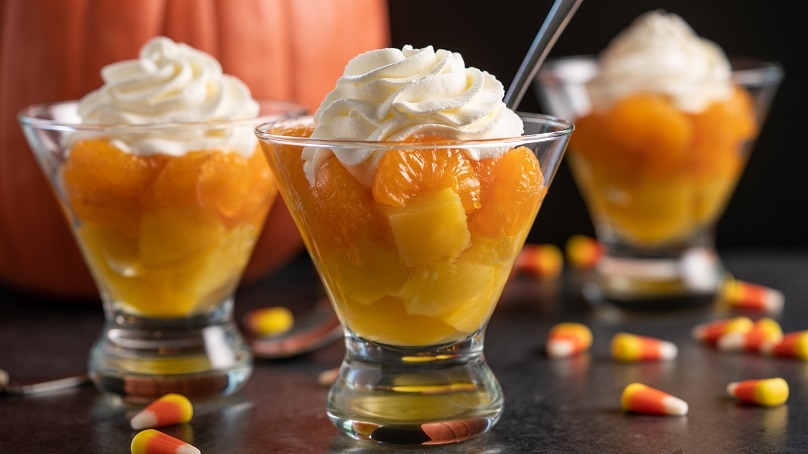 Candy corn fruit parfait cups on a table. 