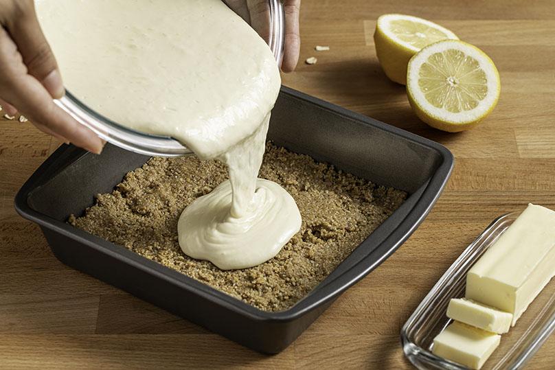 Pouring the cheesecake filling on top of the crust