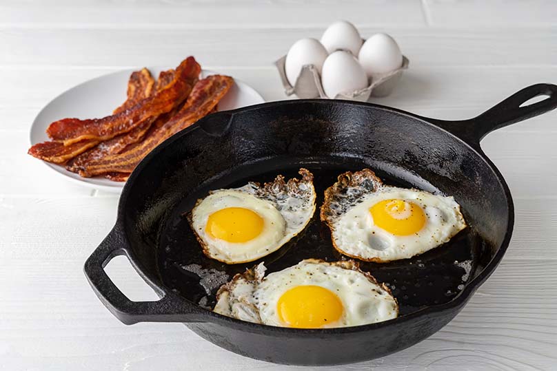 Eggs frying in cast iron skillet