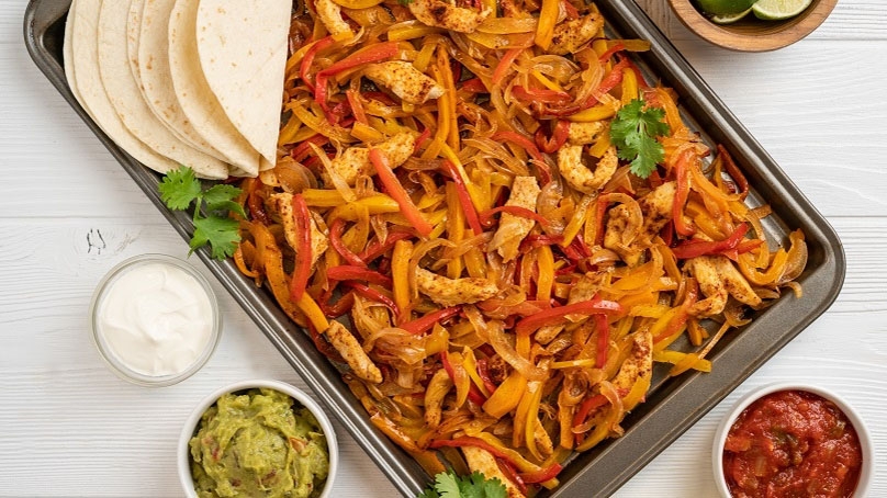 Sheet Pan Chicken Fajitas, tortillas, sourcream, guacamole, salsa, white wod table