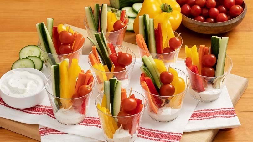 Vegetable Cups with Spicy Ranch Dip, kitchen towel, cutting board, wood table bowl of tomatoes, bell pepper, cucumber slices