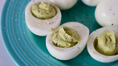 Avocado Deviled Eggs on ribbed teal plate