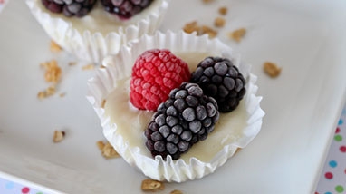 Frozen Yogurt and Granola cups on white serving dish, dotted tablecloth