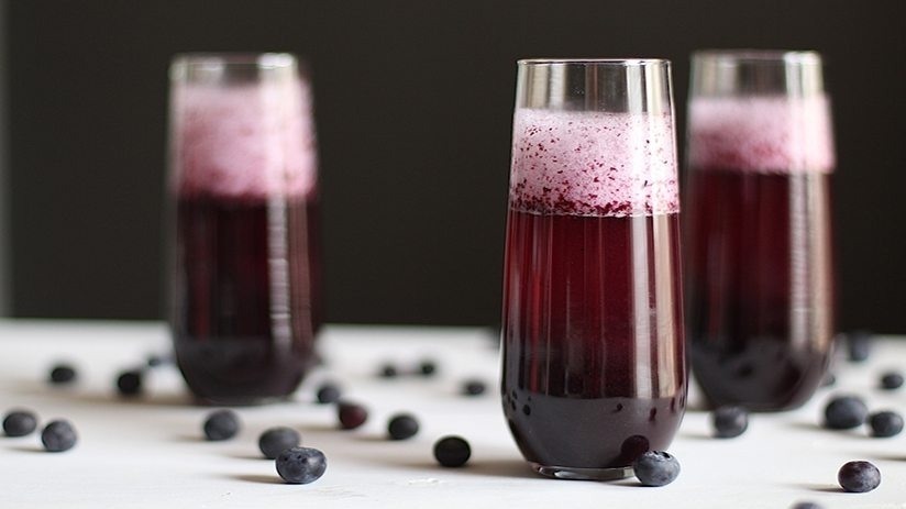 Blueberry Bellini in tall glasses, white table cloth, blueberries