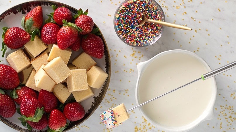 White Chocolate Champagne Fondue on whit counter top, skewers