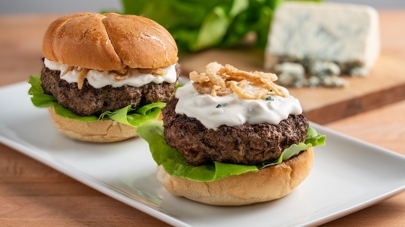 Blue Cheese Burger with lettuce and topped with crispy onions and homemade blue cheese sauce