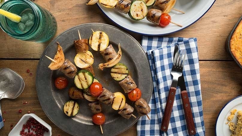 Brat and Veggie Kabobs, fork and knife, blue and white plaid napkin
