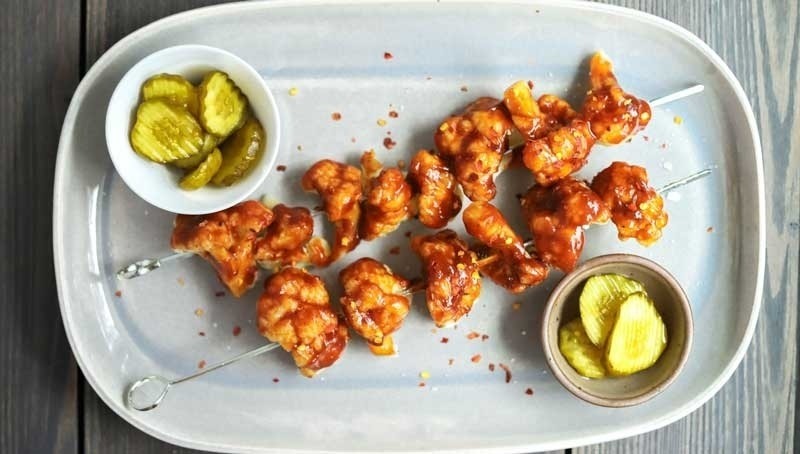 Grilled Cauliflower covered with Barbecue sauce, pickles in serving dish