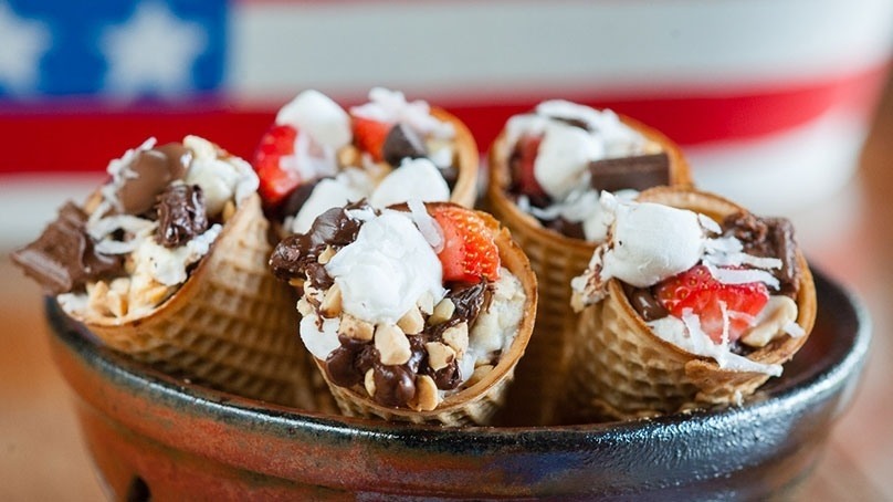 Five  S’mores Cones in shallow bowl, wood counter, american flag bacground