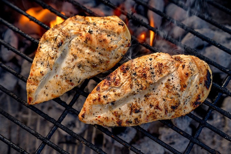 Cooked Chicken Breasts on the grill, glowing coals