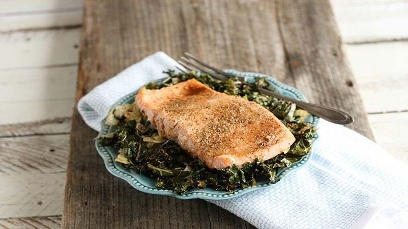 Roasted Salmon with Kale and Cabbage, white plate, white napkin, dark wood table