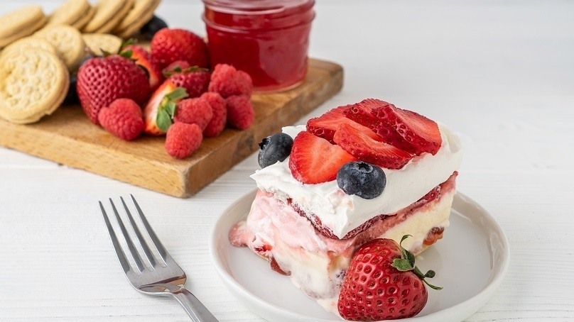 Berry Ice Cream Cake with strawberry, fork, board with strawberries, crackers, jam