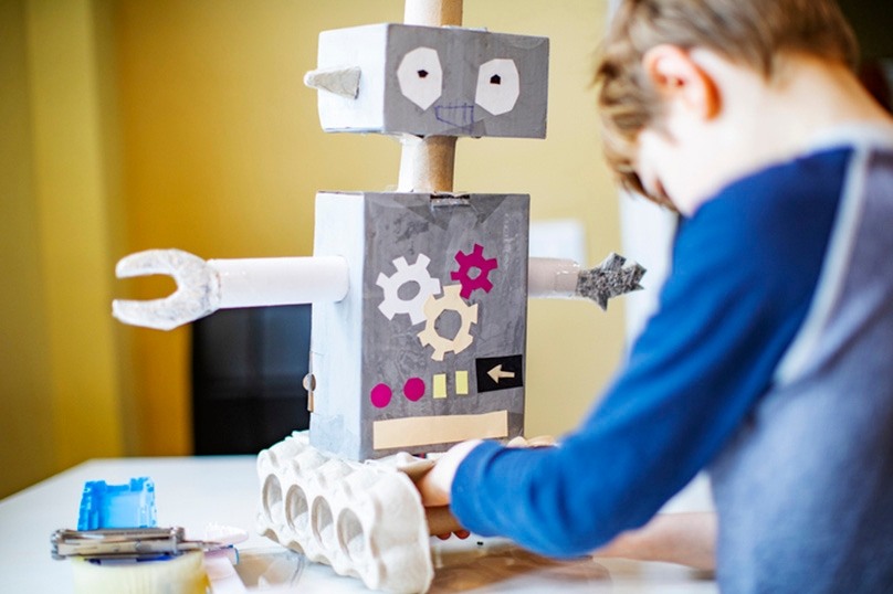child building a rtobot with upcycled hoeshold goods