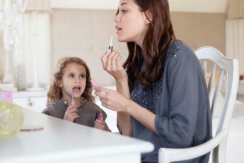 Mom and daughter applying makeup