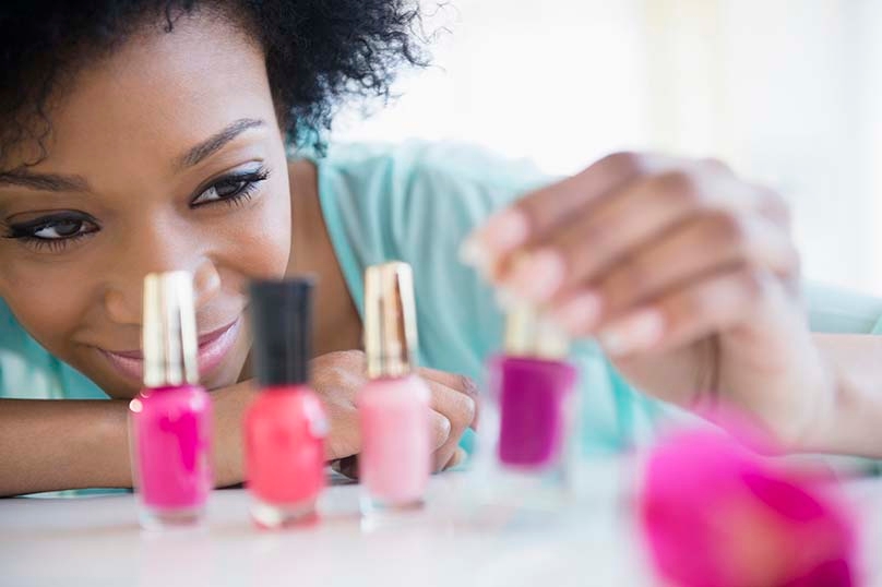 Woman with nail polish bottles on counter