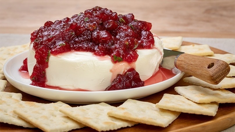 Cranberry Cream Cheese Dip surrounded by crackers on cutting board