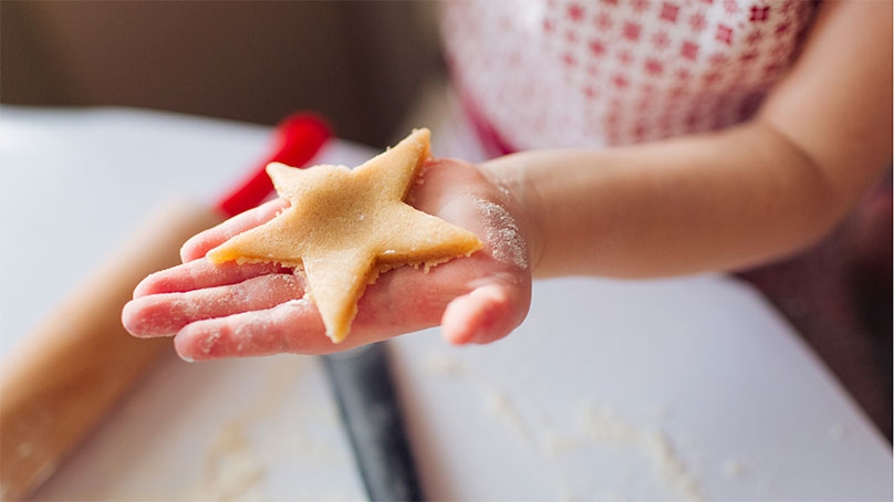 Child holding unbaked sugar cookie