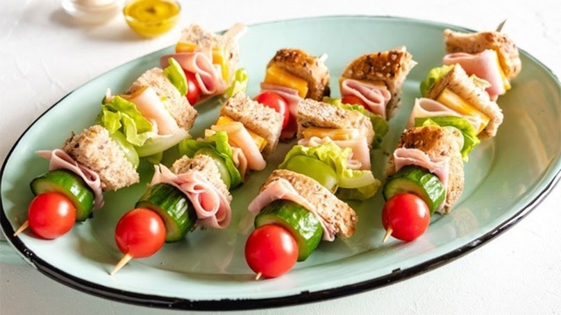 Sandwich Skewers on plate, small dish of mustard and mayonaise on counter top