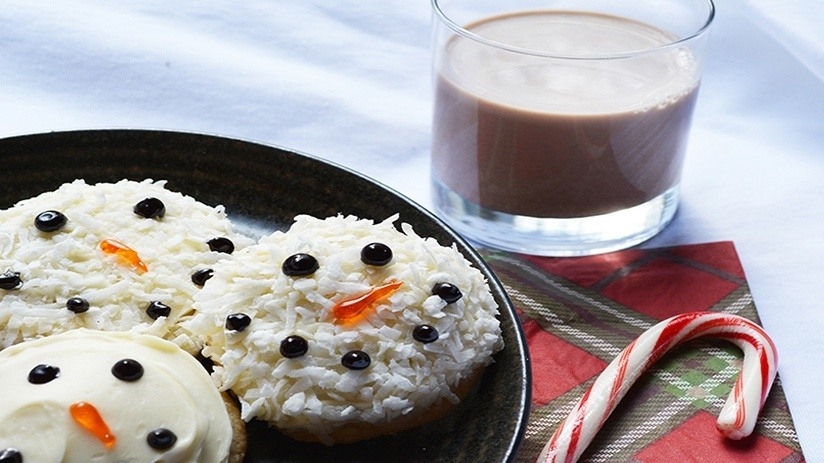 Snowman Sugar Cookies on black plate, plaid placemat, candy cane,