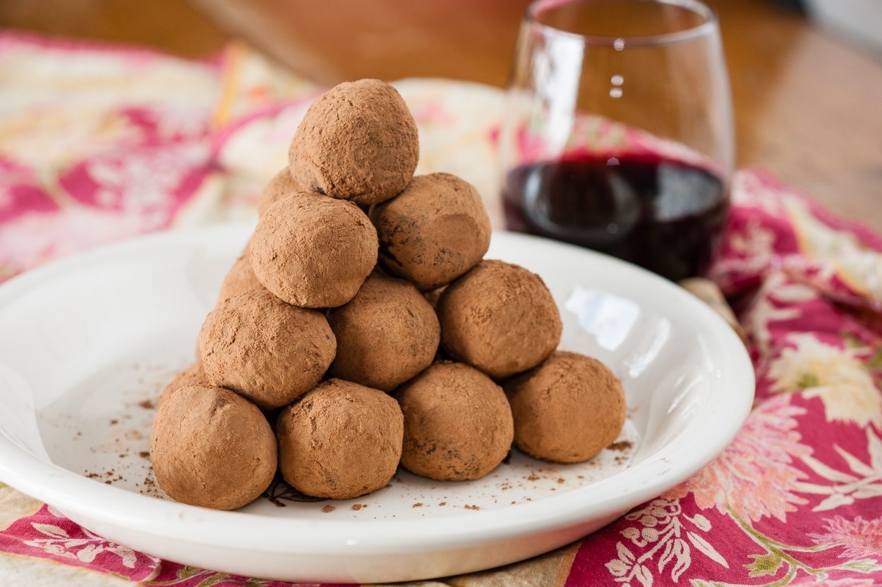 Red Wine Chocolate Truffles starting acked on white plate, brocaide olacemat