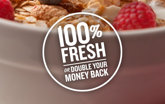 100 percent fresh or double your money back guarantee, white cereal bowl with milk, cereal and berries on spoon